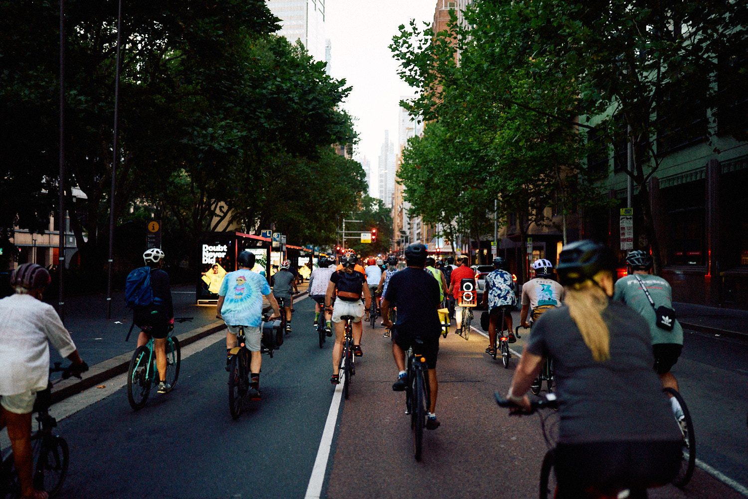 Hundreds of riders filling a Sydney street at golden hour